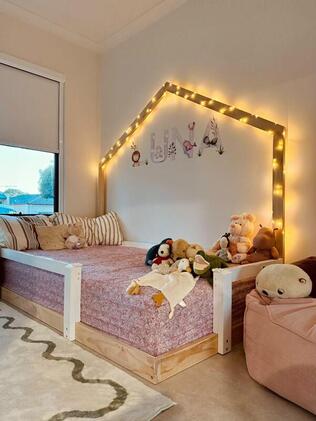 Picture of bed base on the floor with white rails and back house frame